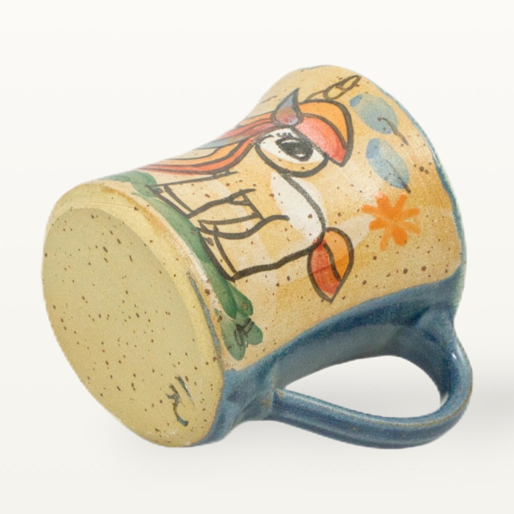 Blick auf den unglasierten Standring und das Werkstatt-Siegel von Meisterkeramik am Boden der grünen Einhorn-Tasse.